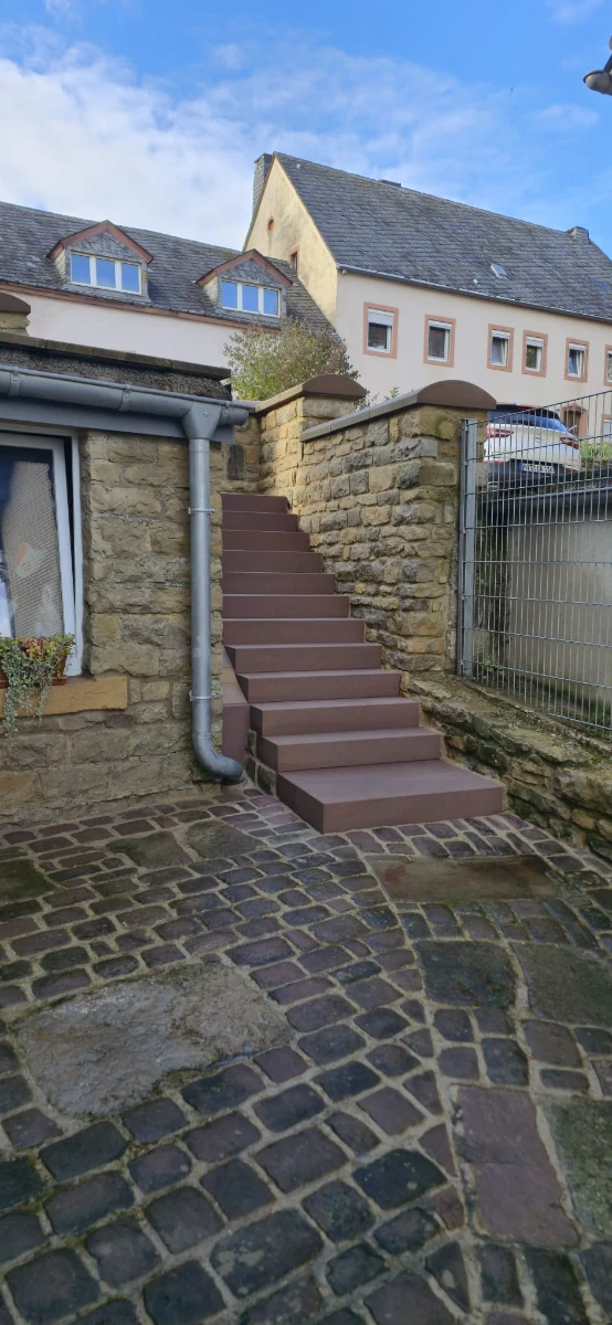 Nettoyage d’escaliers extérieurs en pierre dans une cour pavée